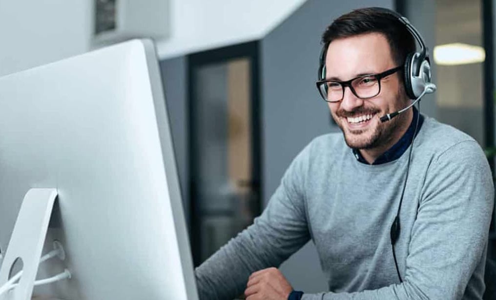 man smiling while looking at computer screen