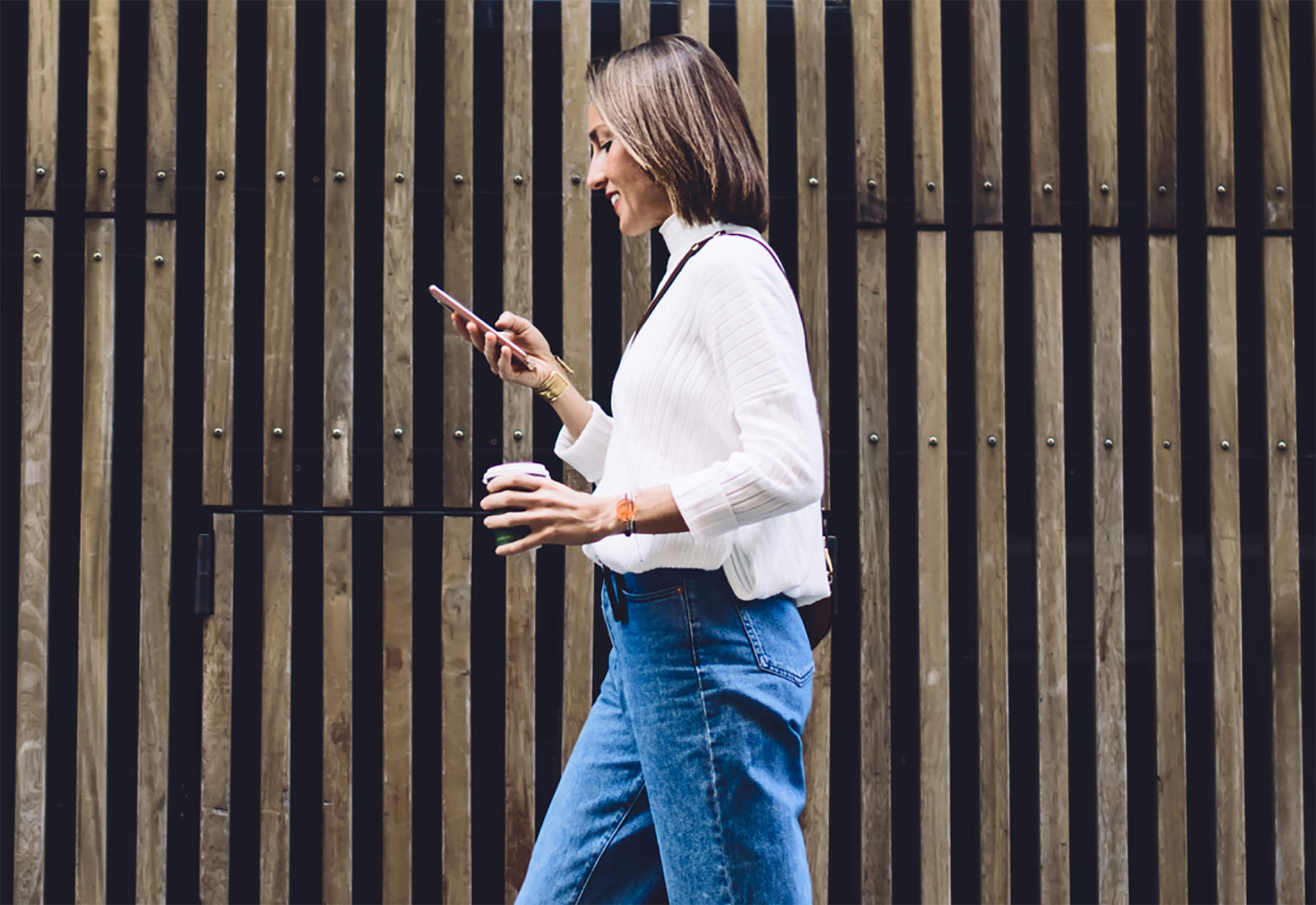 Woman walking and using a phone outside